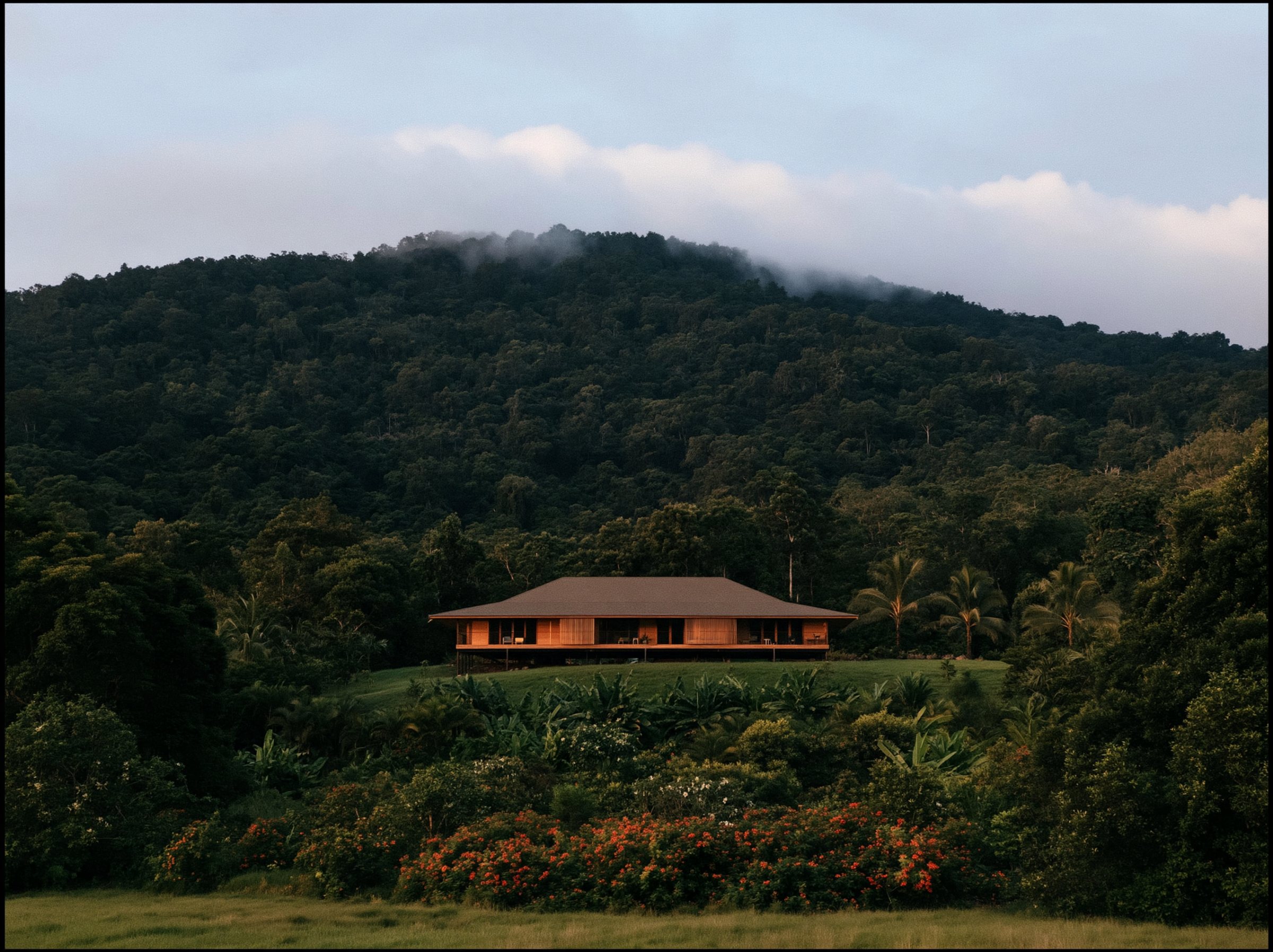 A hip roof with deep eaves over a raised timber house, the hill falling away behind