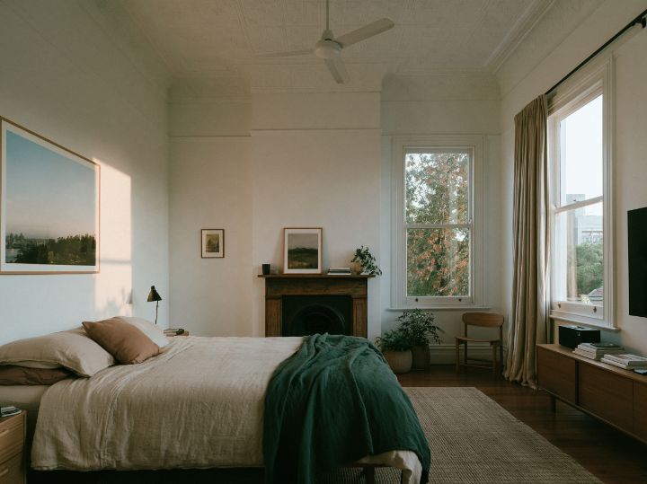 A front bedroom in the old house, high ceiling, a fireplace kept as it was