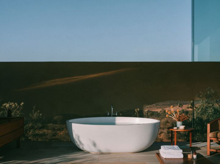 A bath in an earth-walled room, a slot window high on the west